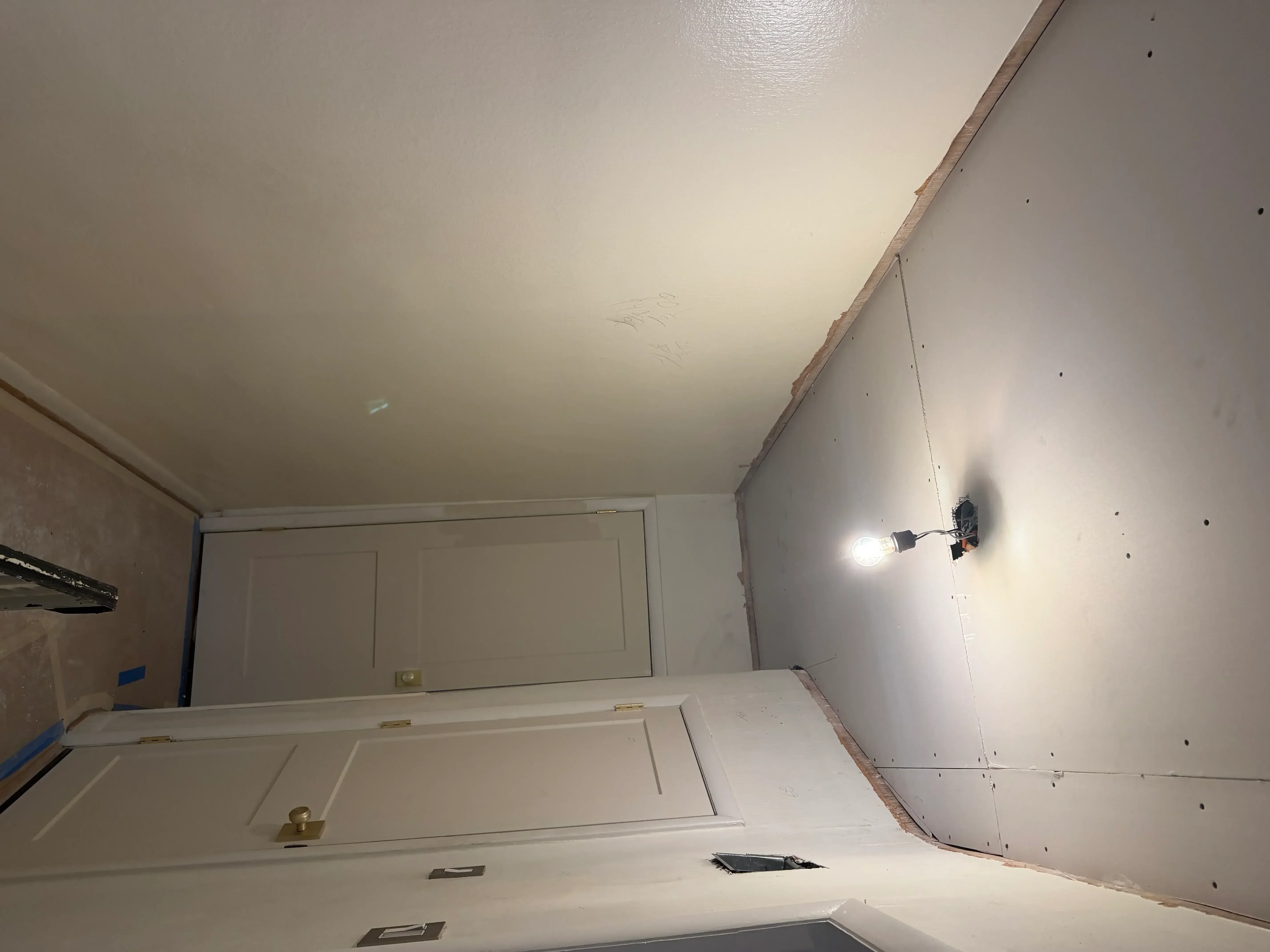 Drywall-finished walls and coffered ceiling with primer and recessed lighting installation