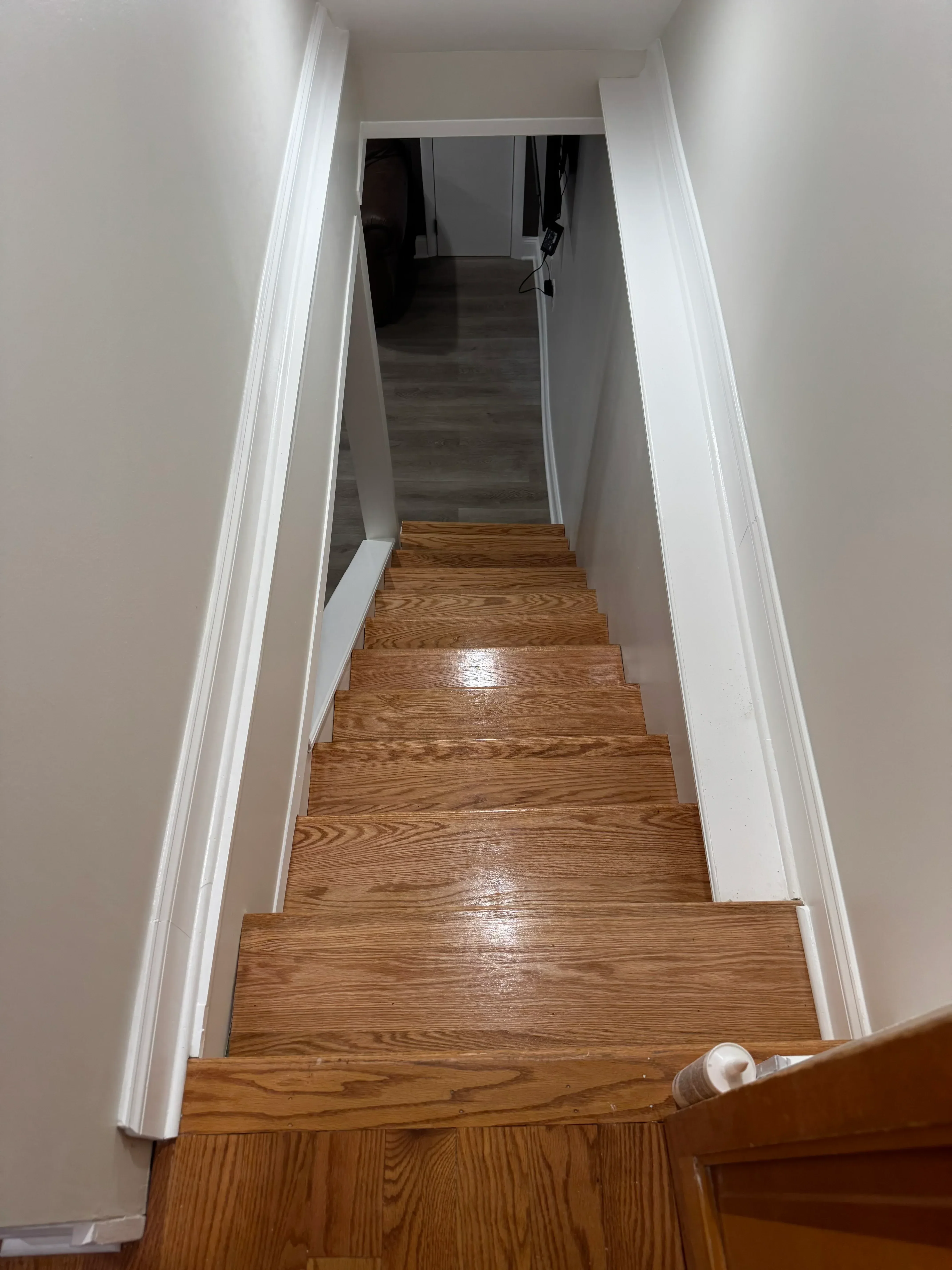 White painted trim and soffit with oak wood cabinetry and detailed crown molding installation