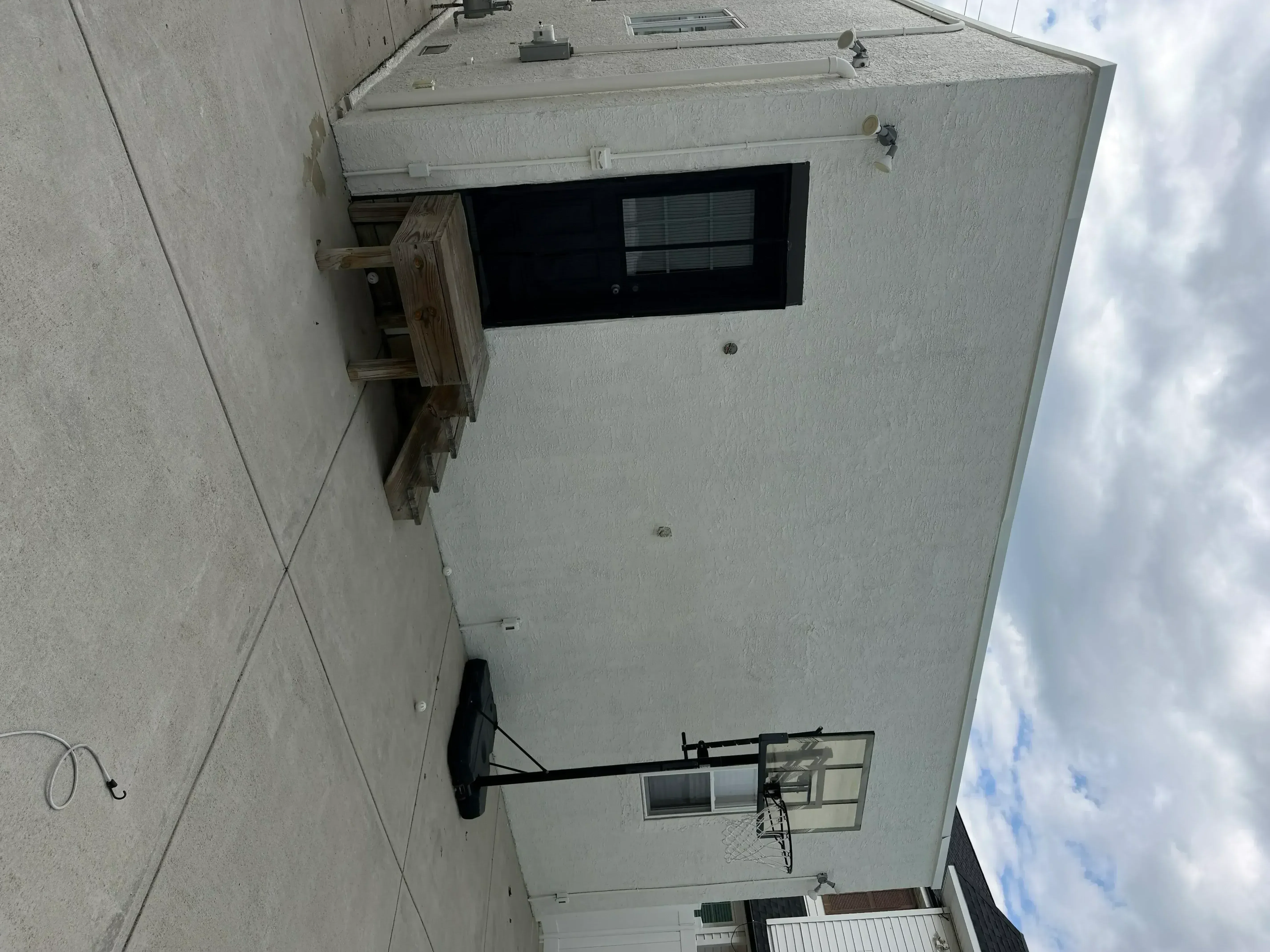 Freshly painted exterior stucco wall with white trim and window frame