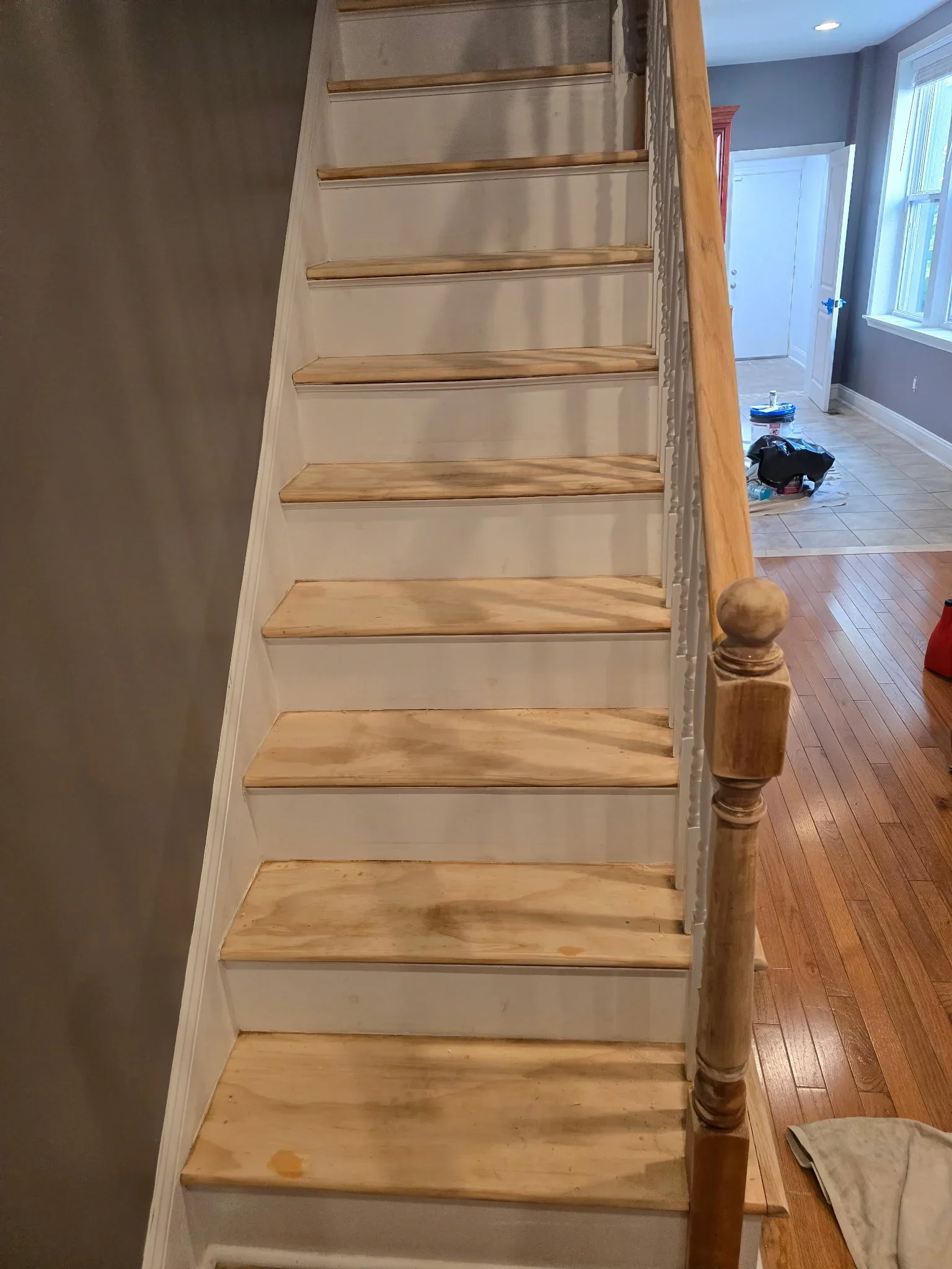Painted interior staircase with gray risers, natural wood treads, and wooden balusters