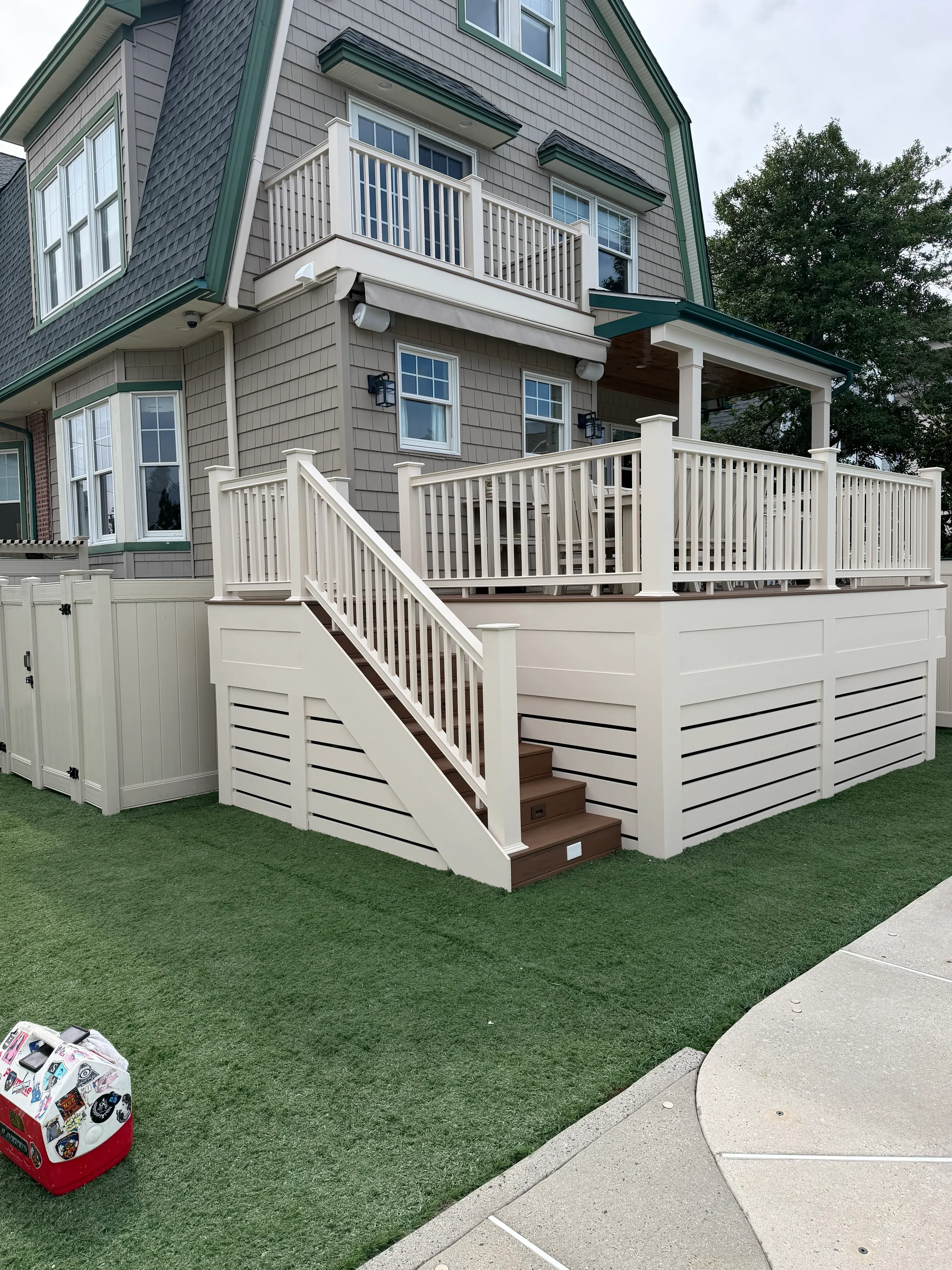 Cream and white painted exterior shutters and trim on residential home with gray metal roof