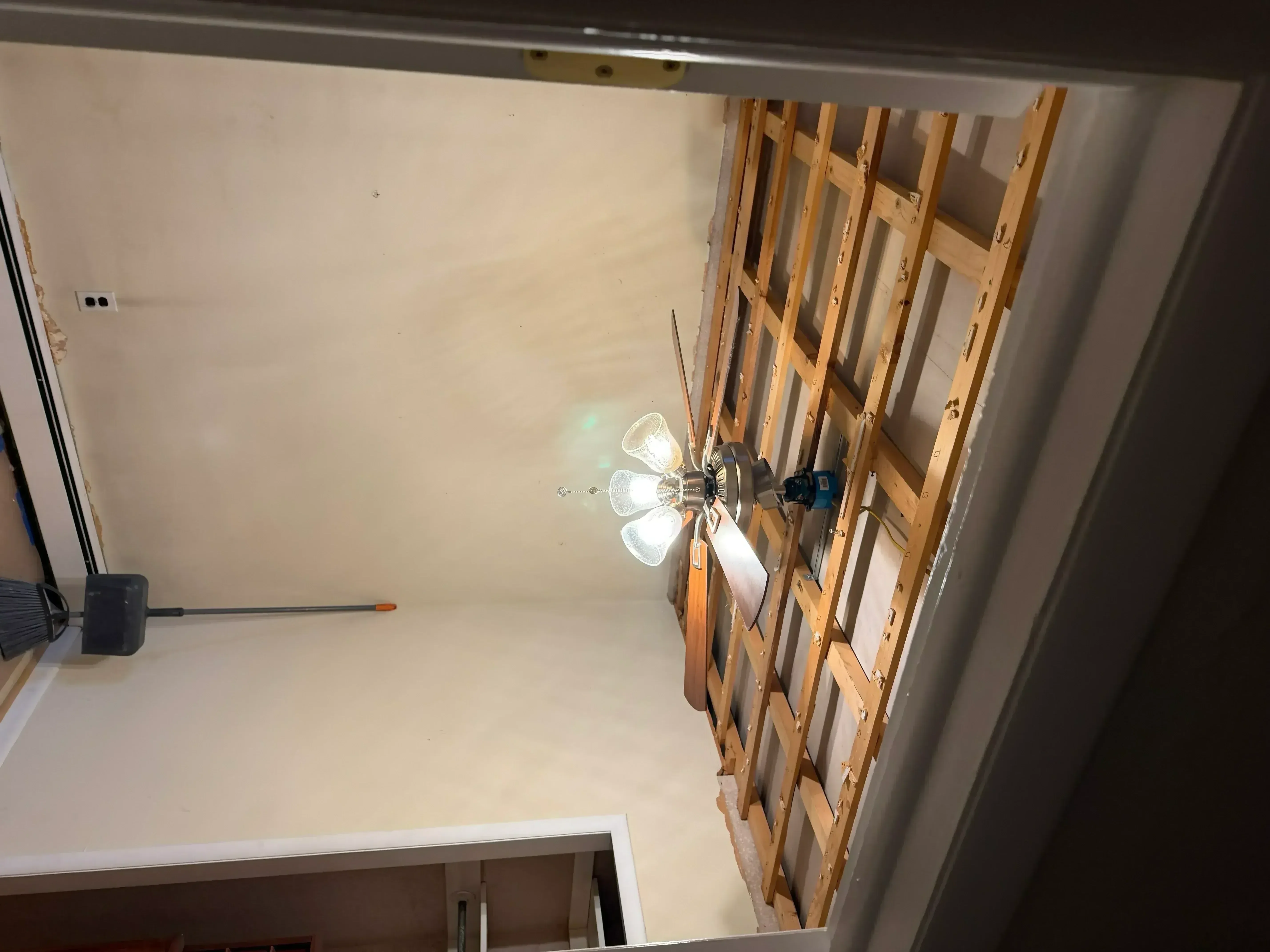 Drywall installation with taped seams, wooden framing, and finished joint compound on walls and ceiling