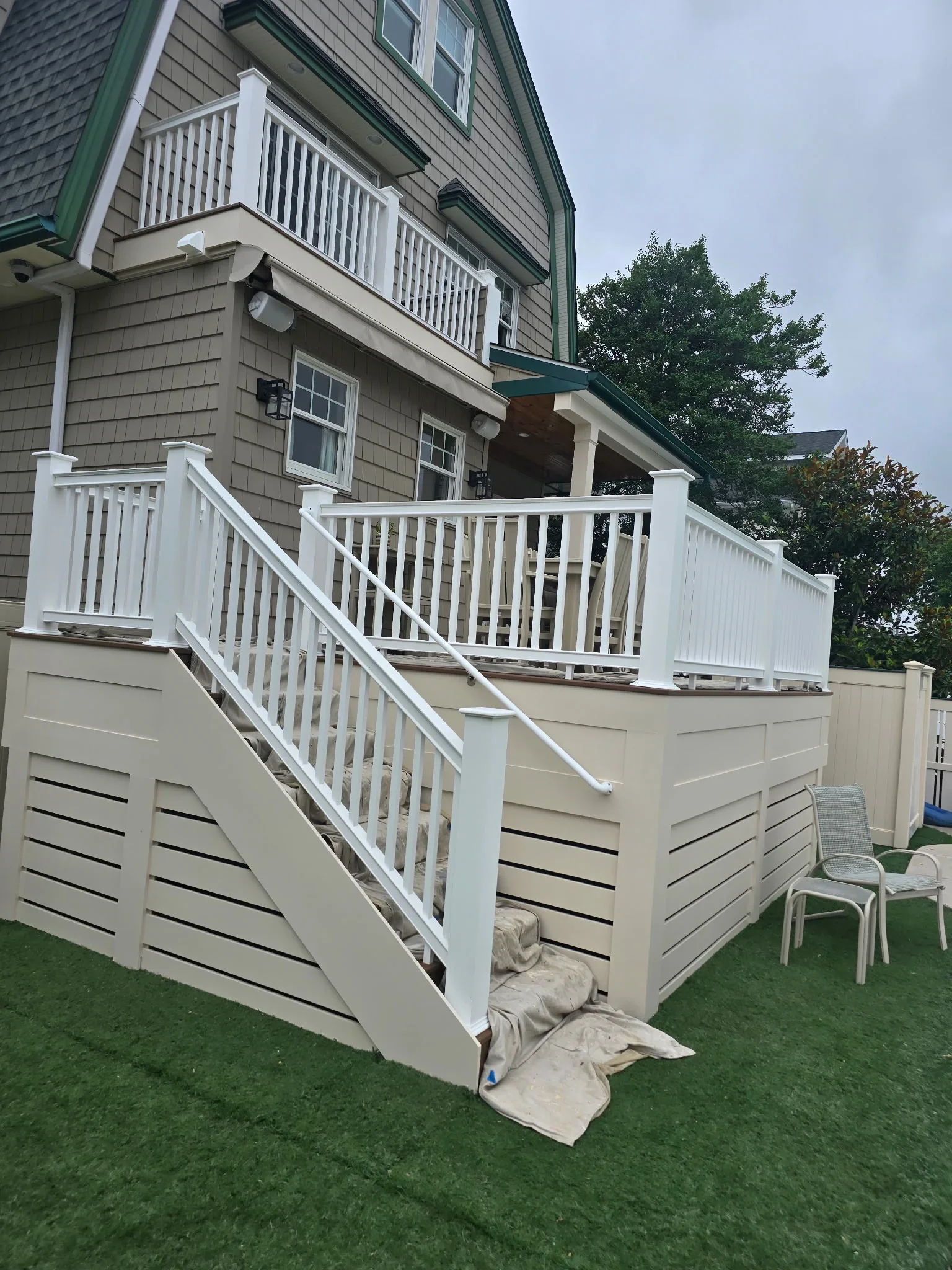 White painted deck railings and skirting on multi-level residential structure with horizontal slat design