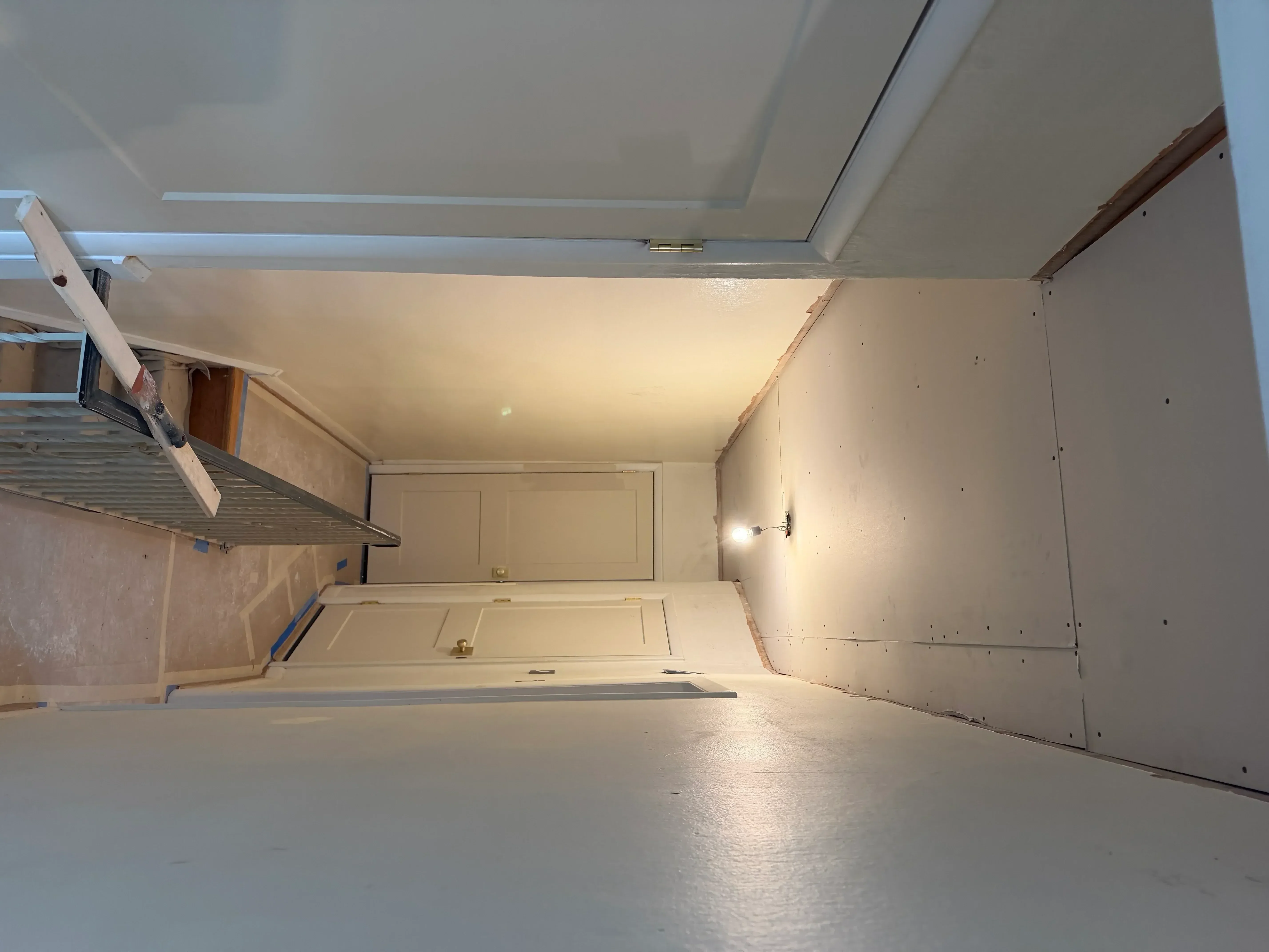 Garage interior with primed drywall walls, ceiling, and recessed lighting installation