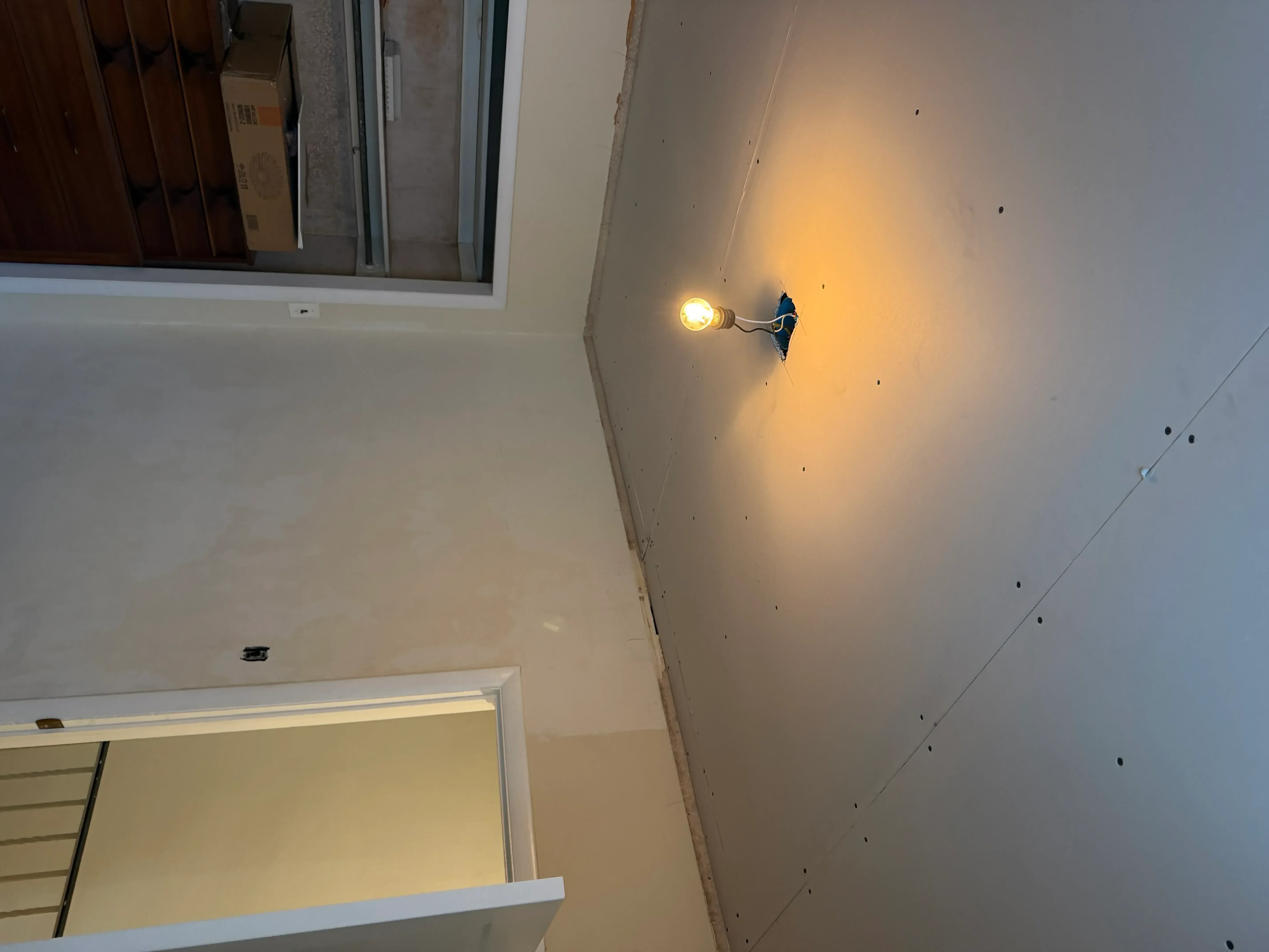 Freshly painted drywall ceiling with recessed lighting fixture and white trim molding