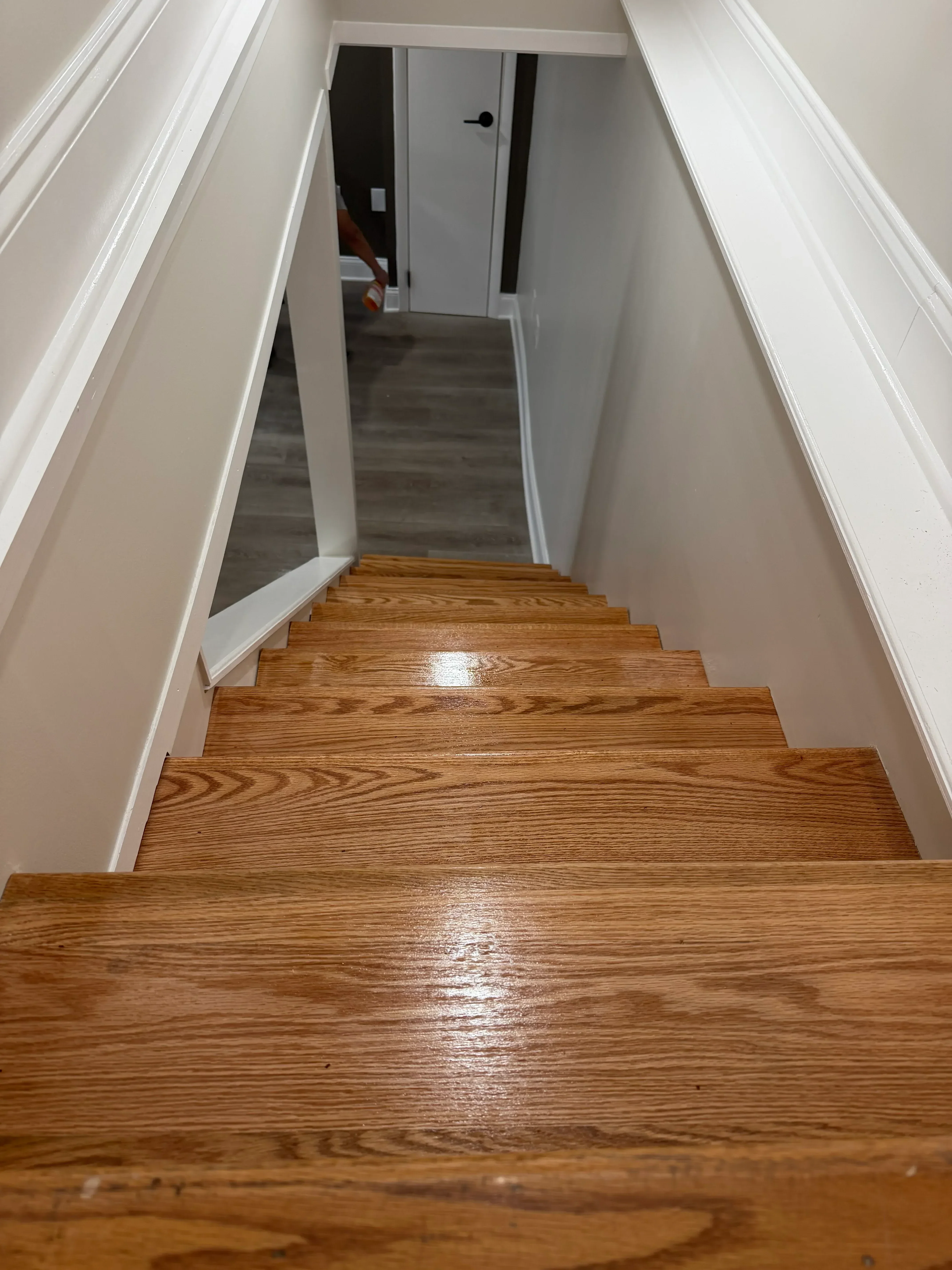 White painted trim and ceiling with oak wood wall paneling on interior staircase