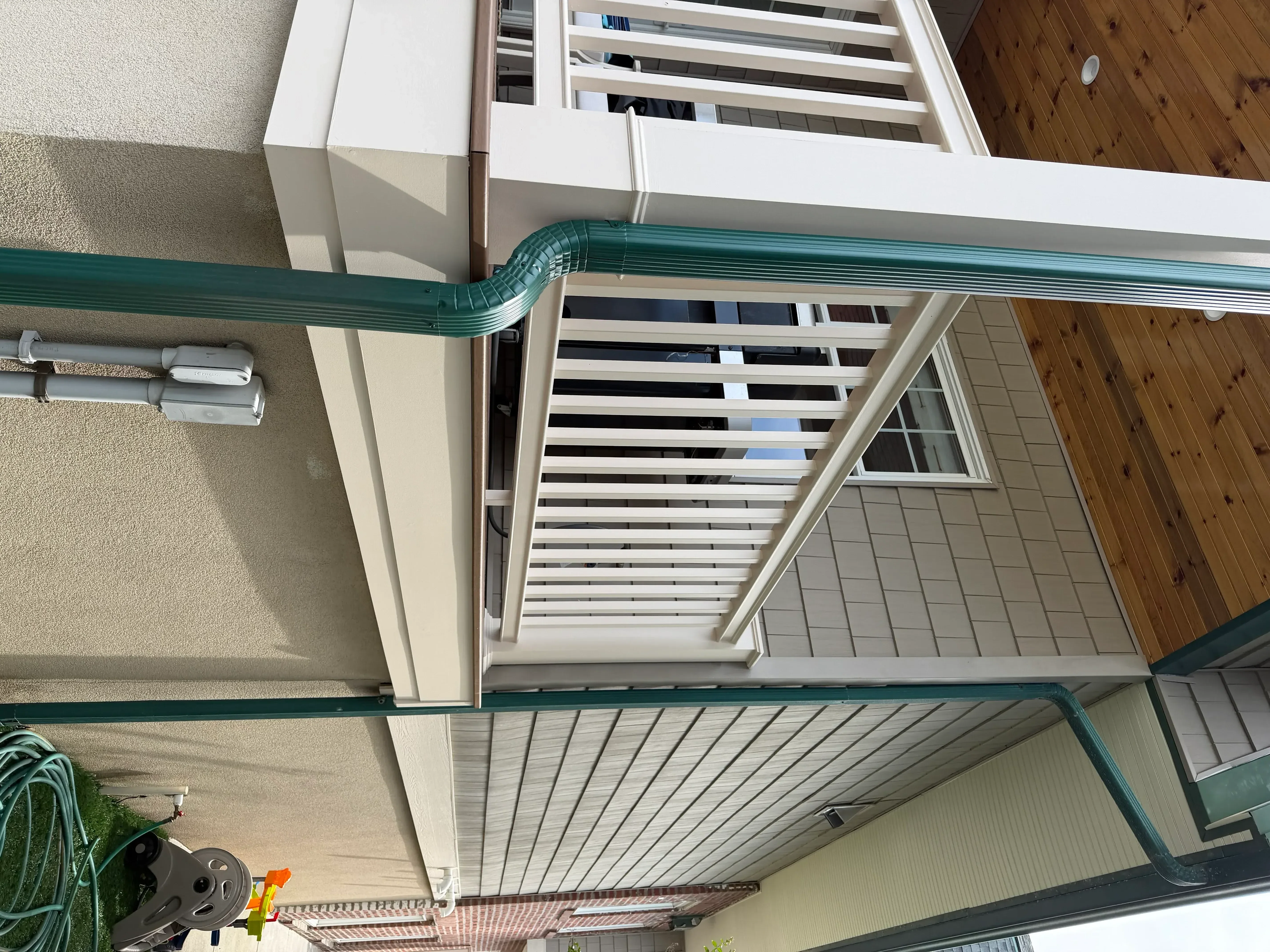 White and gray painted fascia, soffit, and trim around residential exterior window and gutter system