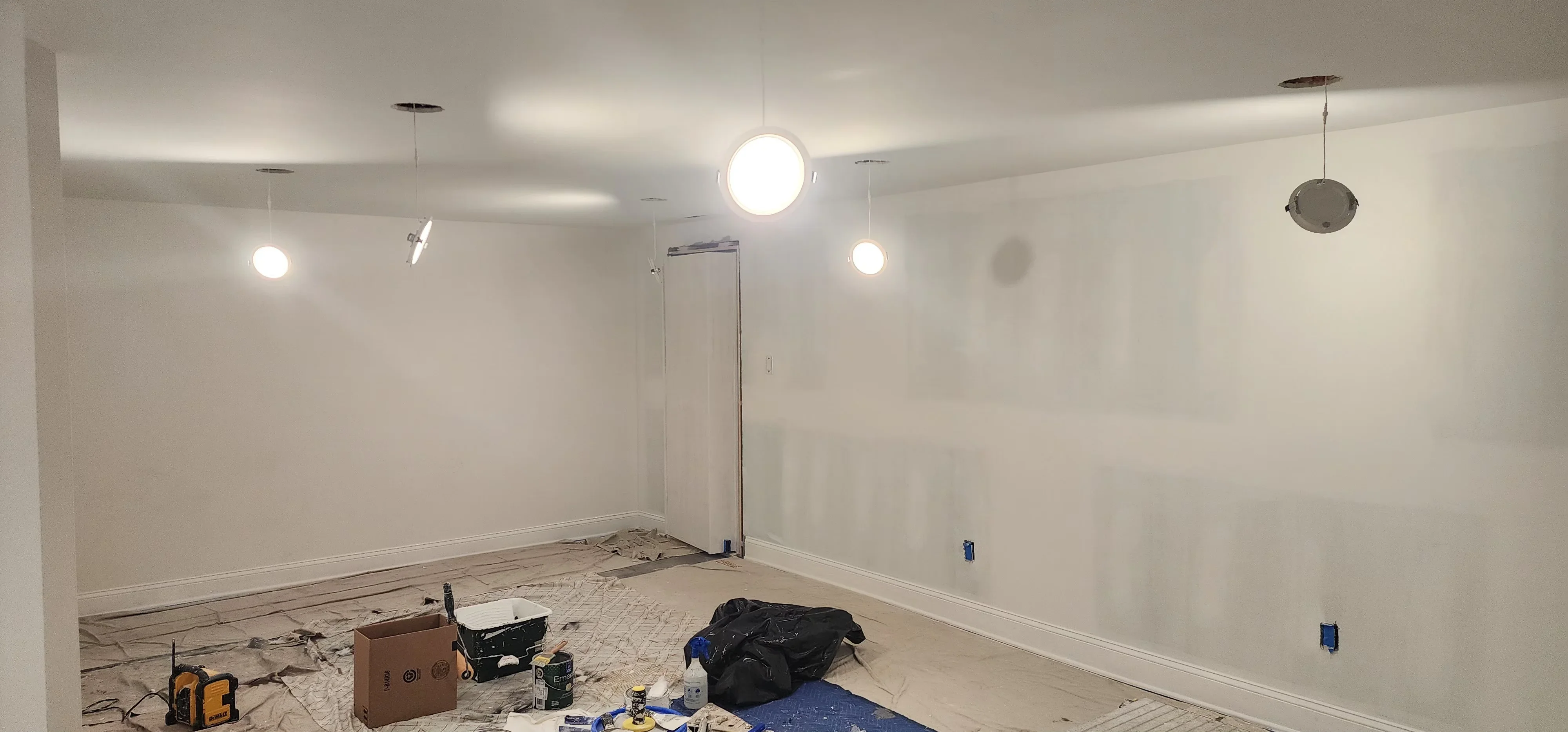 Finished drywall walls with recessed and pendant lighting fixtures in commercial interior space