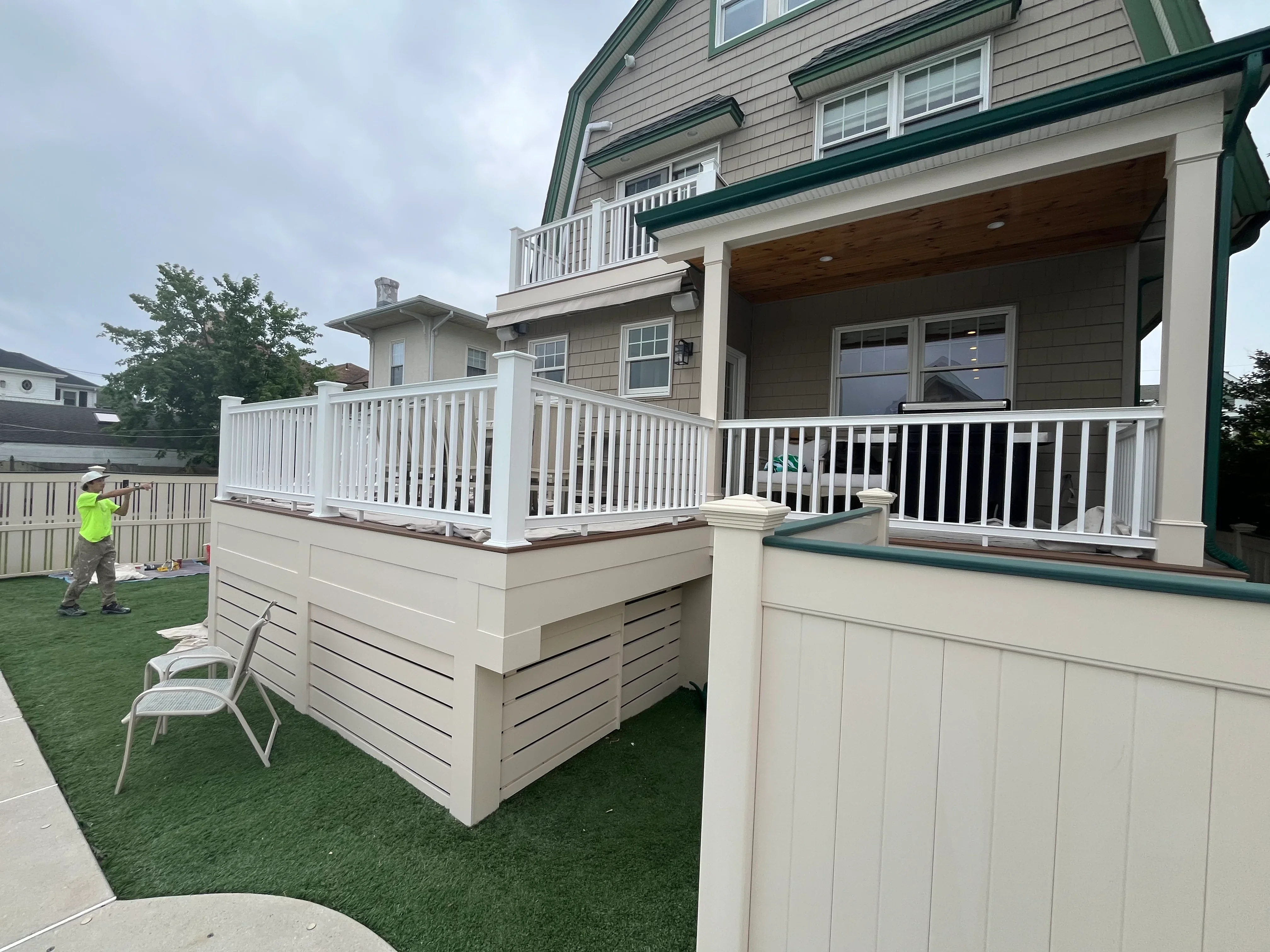 White vinyl deck railings and cream horizontal skirting panels on elevated residential deck structure