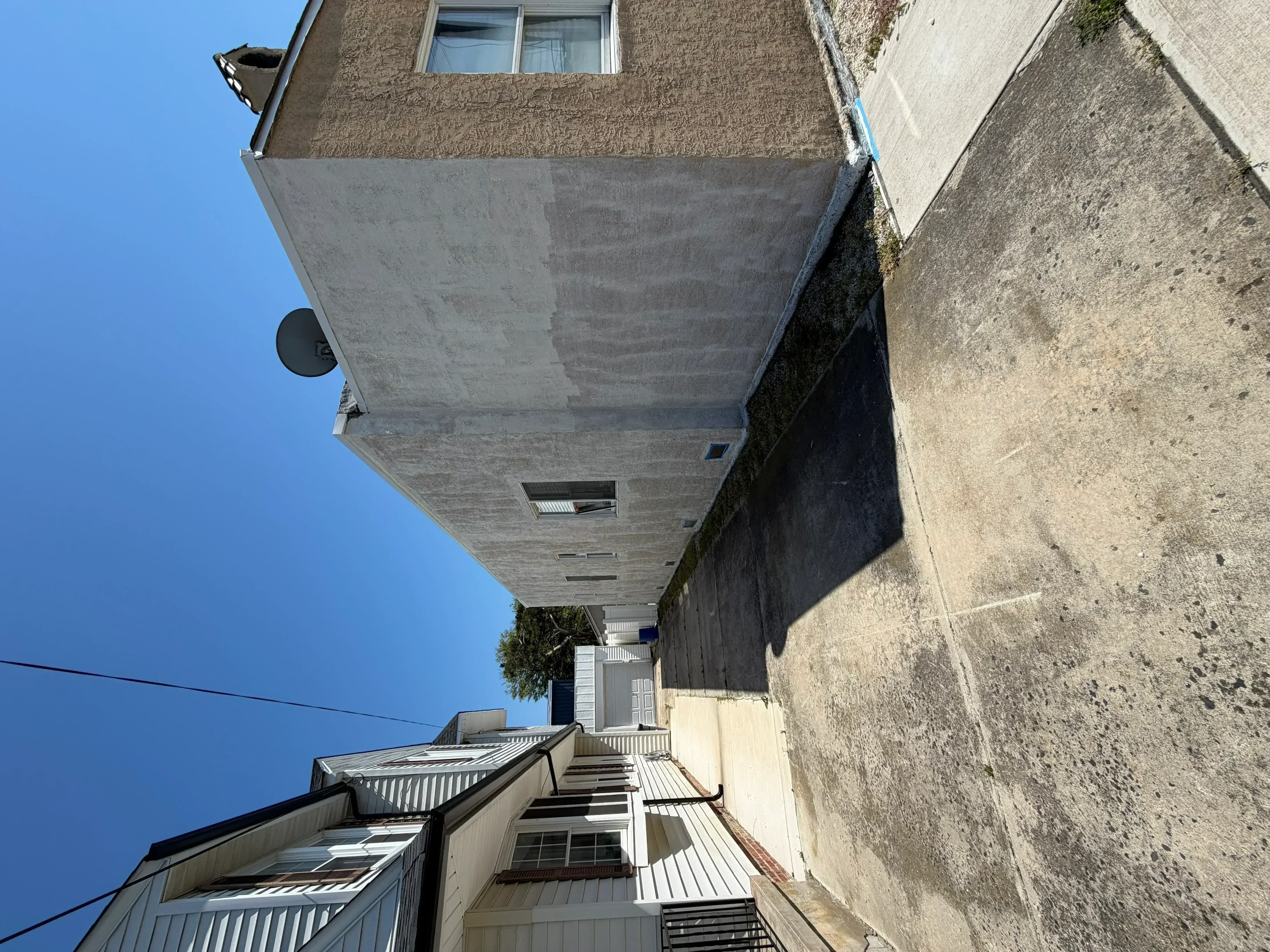 Exterior house with freshly painted stucco facade and concrete foundation walls